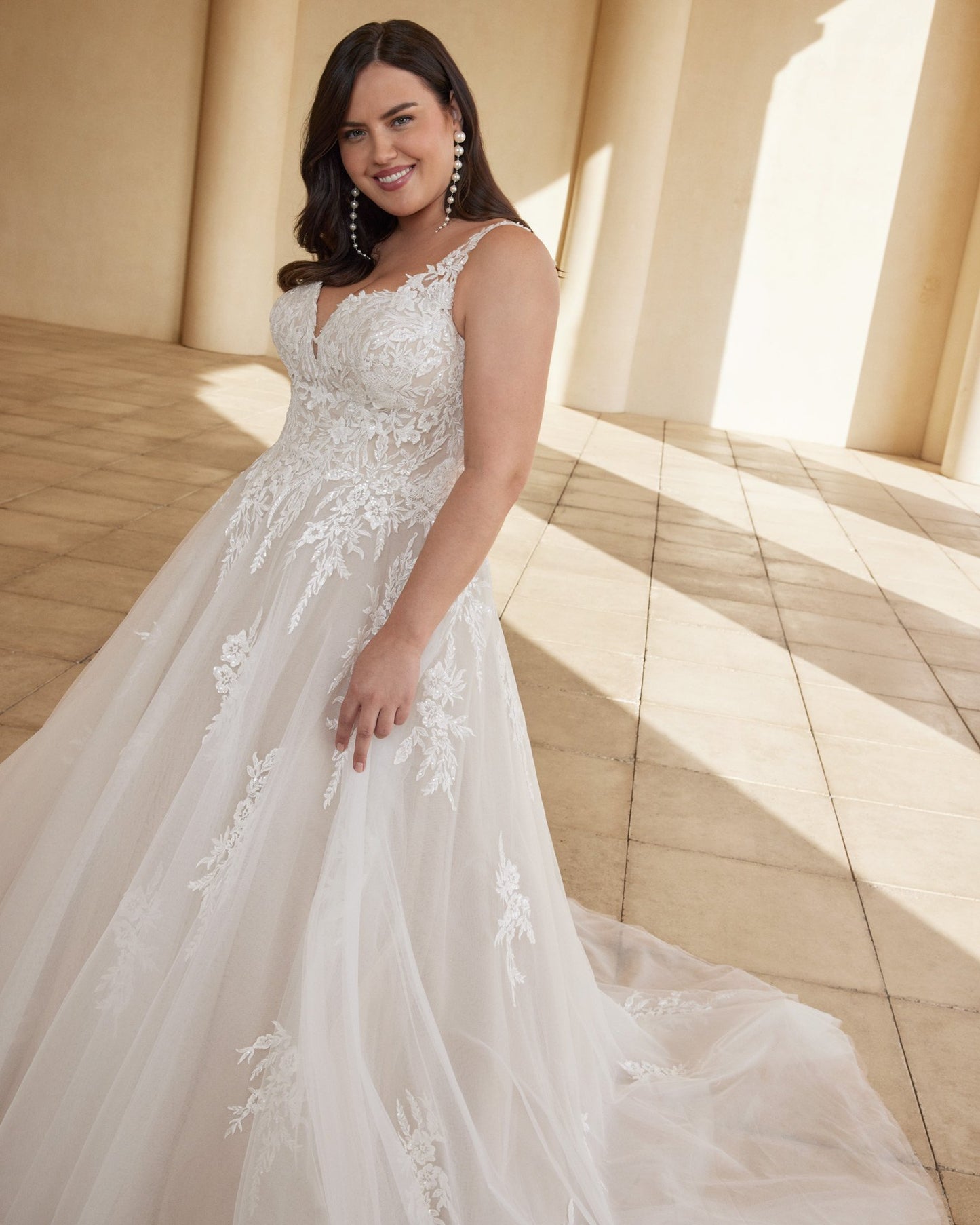 A-line curvy bridal gown featuring floral lace and natural waist fit
