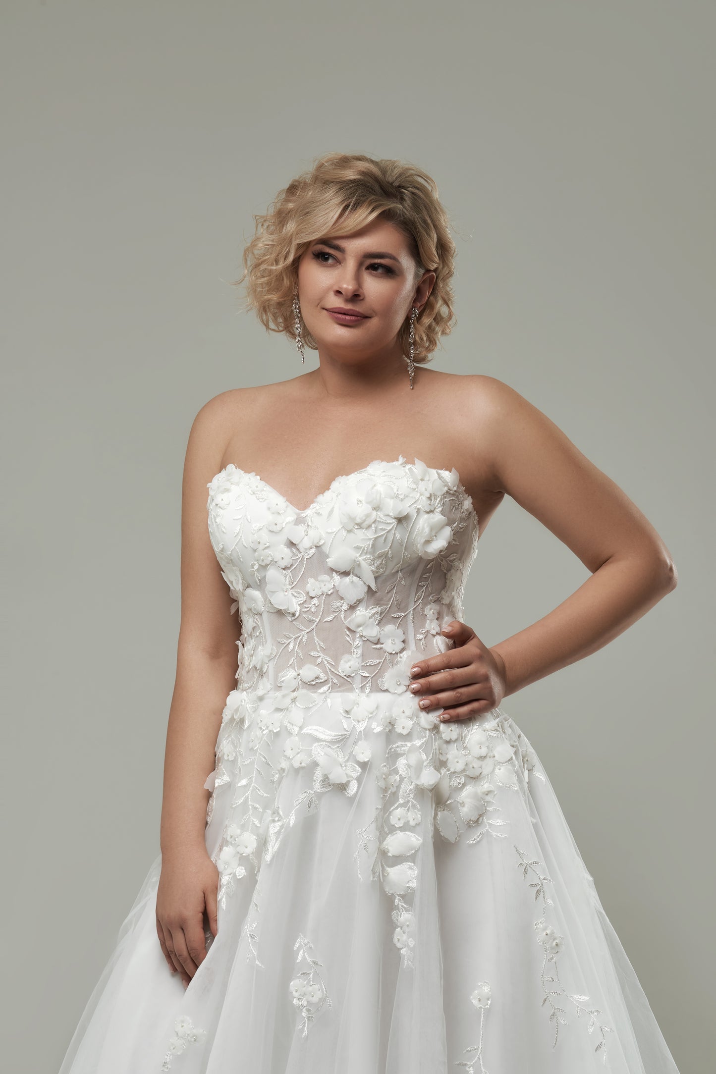 Curvy bride in A-line tulle wedding gown with floral detailing and flattering silhouette