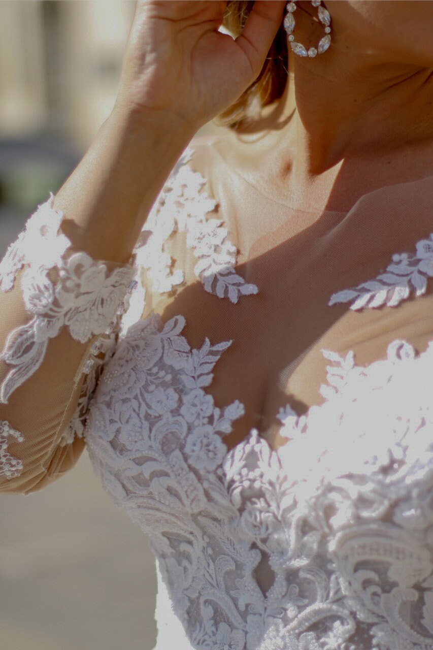 Curvy bride in scoop neck lace gown with long sleeves and full tulle skirt — perfect for a classic wedding