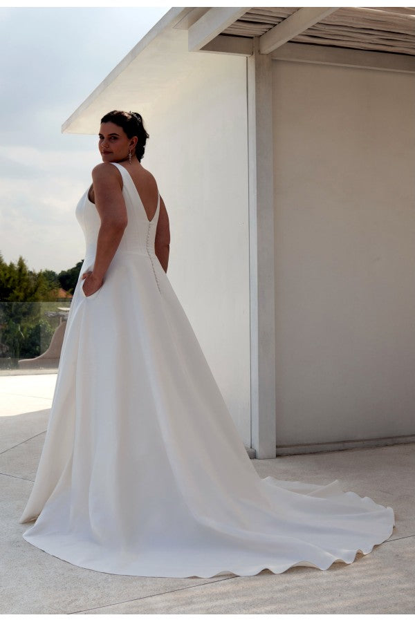 Curvy bride in sleeveless satin A-line gown with deep V neckline and custom fit