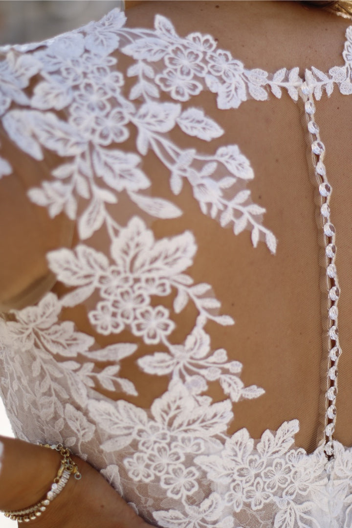 Custom made plus-size wedding gown with long sleeves, illusion neckline, and lace embellishment
