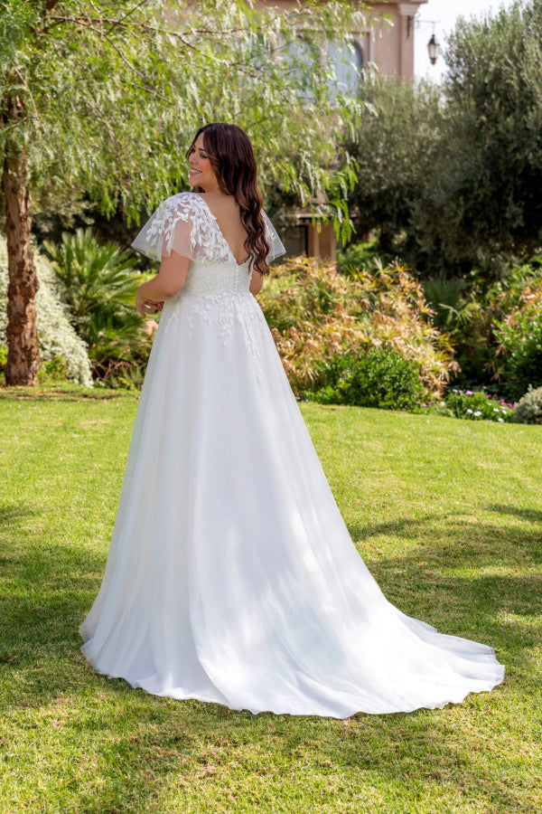 Elegant bridal look for plus size bride with lace bodice and soft layered skirt