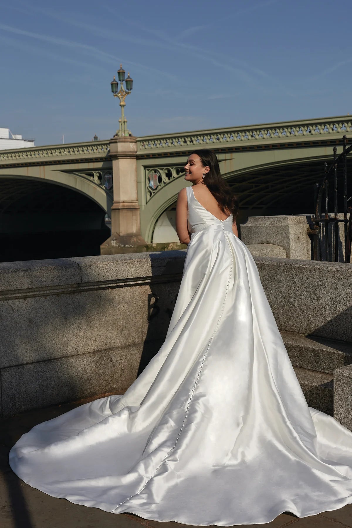 Back view of elegant plus size satin wedding dress with button detail and train