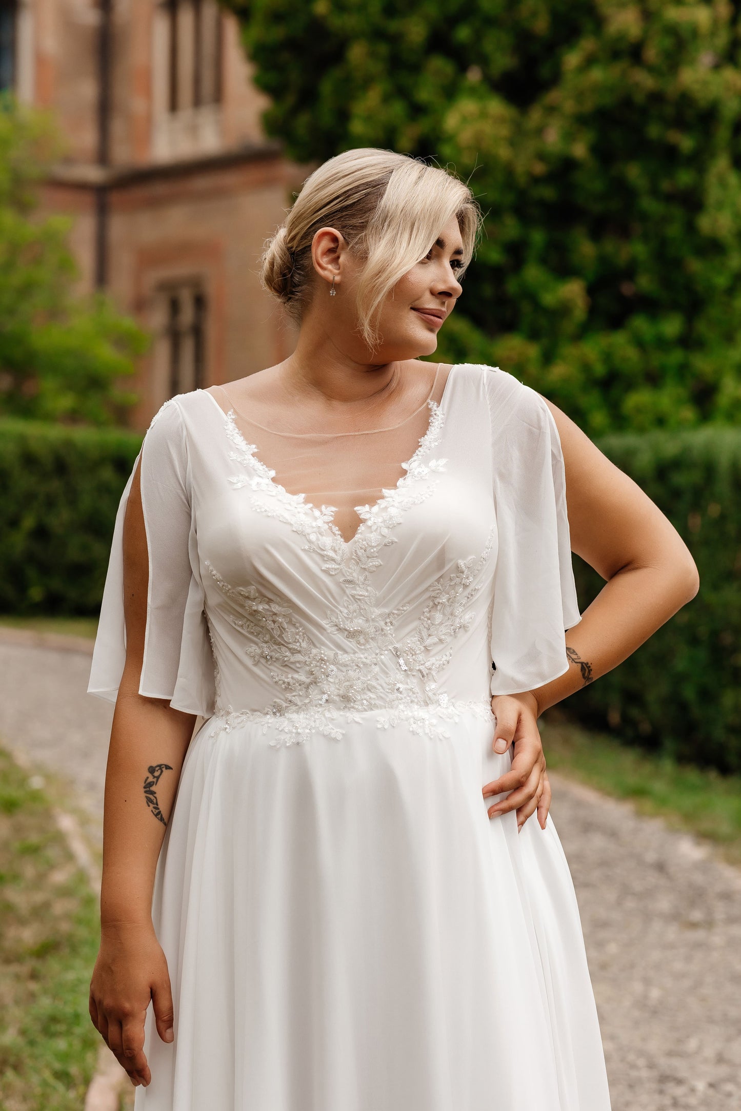 Wedding gown with illusion neckline and lace embroidery designed to flatter plus-size body shapes