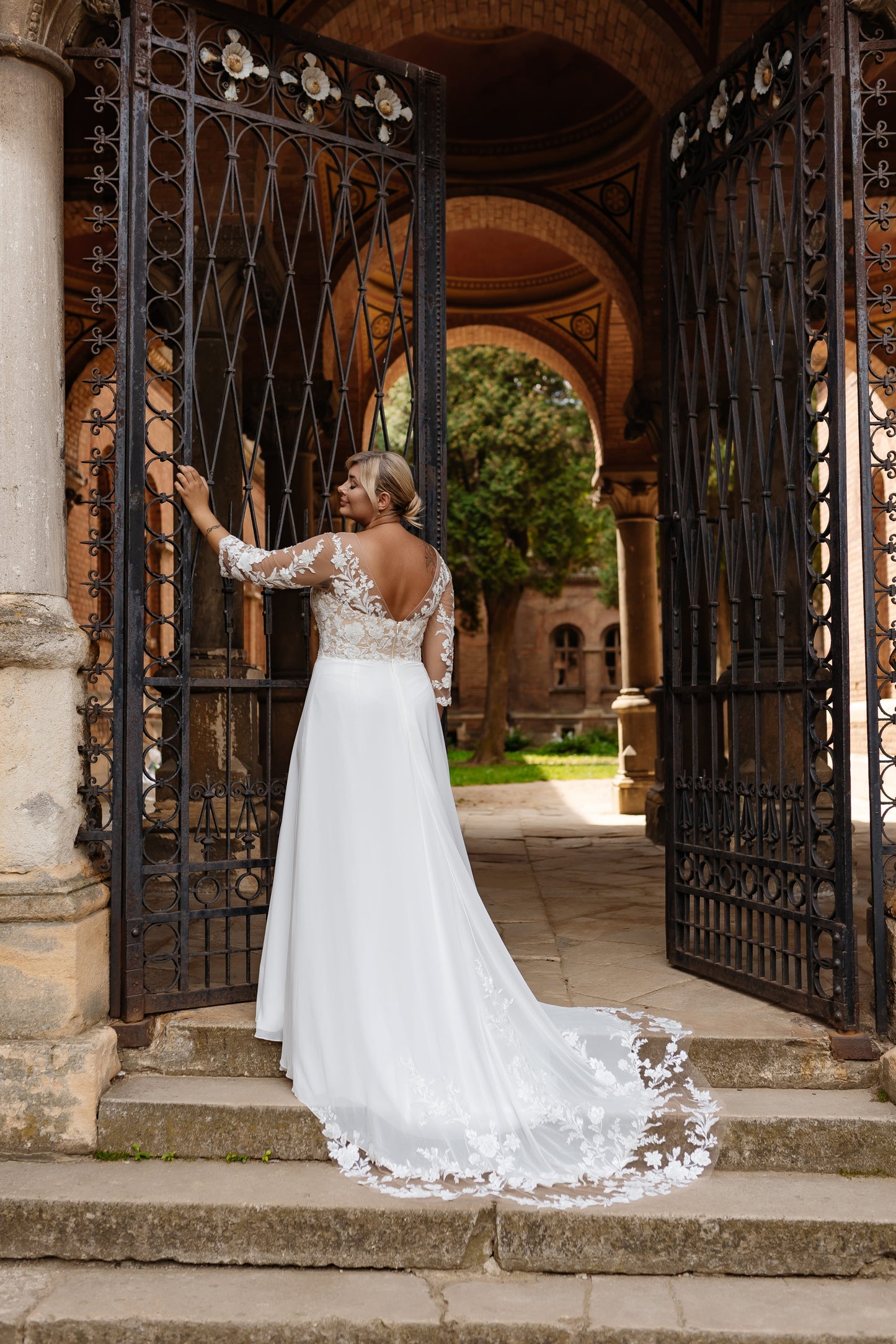 Curvy bridal gown with lace appliqué and sheer detailing, perfect for romantic weddings