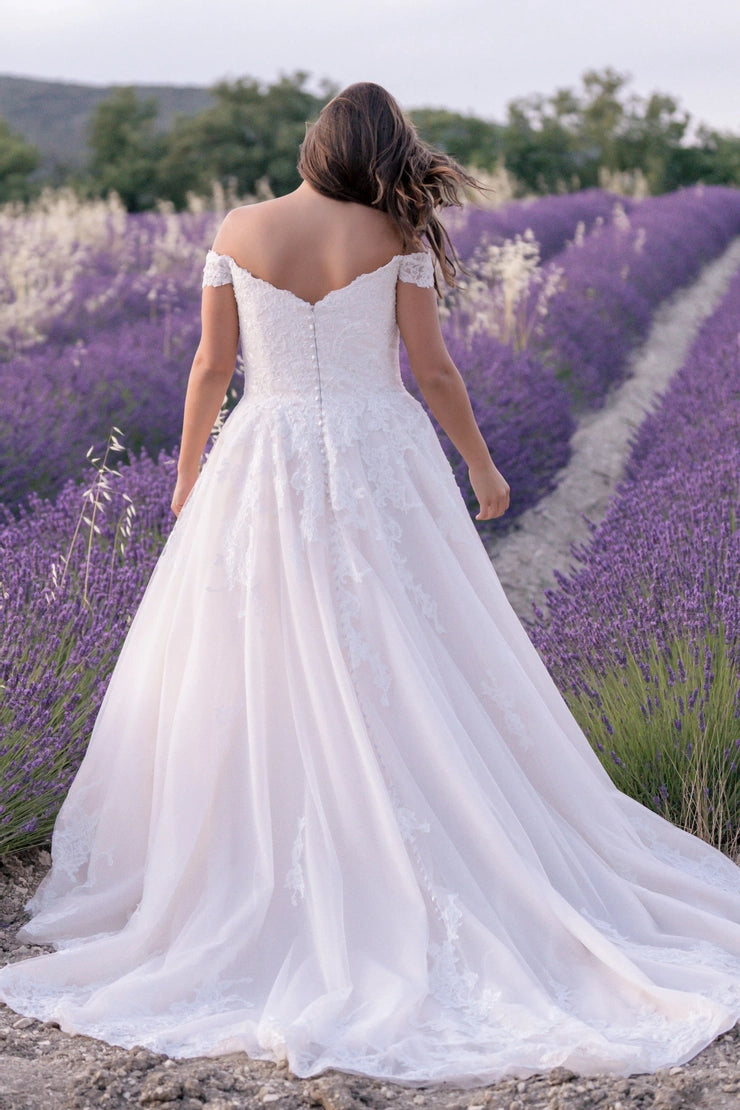 Detailed lace bodice and button back on plus-size wedding gown with soft flowy skirt