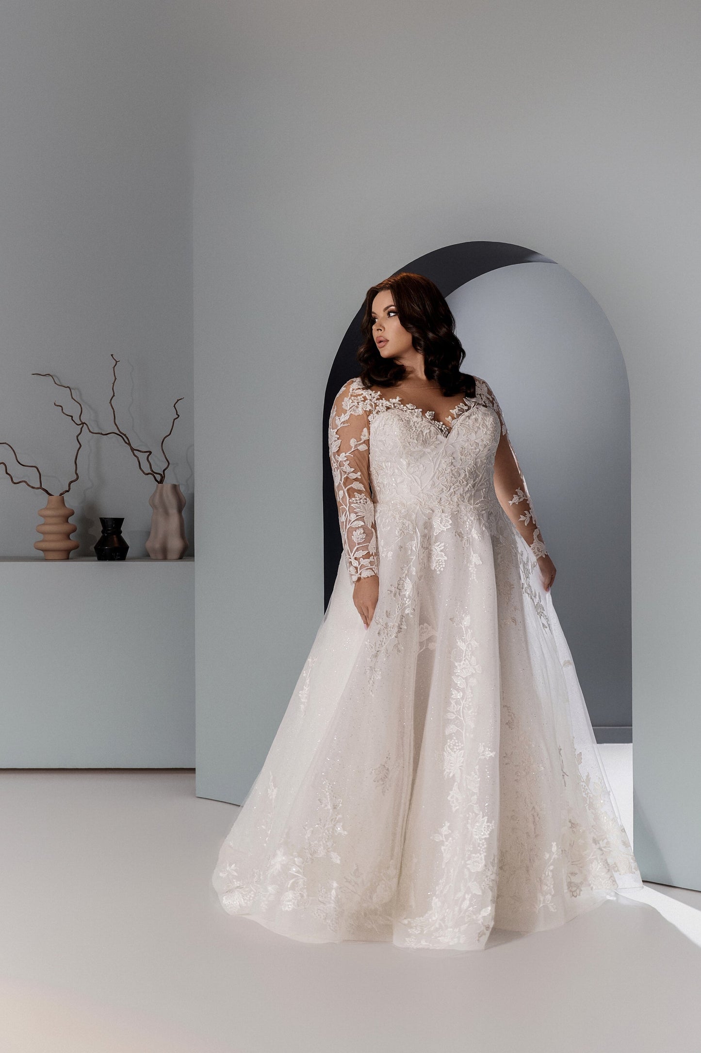 Curvy bridal gown with long illusion sleeves and floral lace appliqués