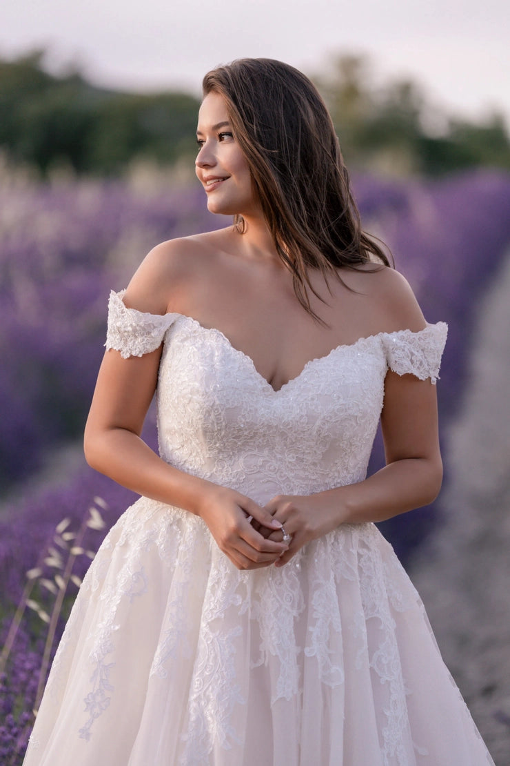 Curvy bride in off-shoulder lace wedding gown walking through lavender field — dreamy and poetic