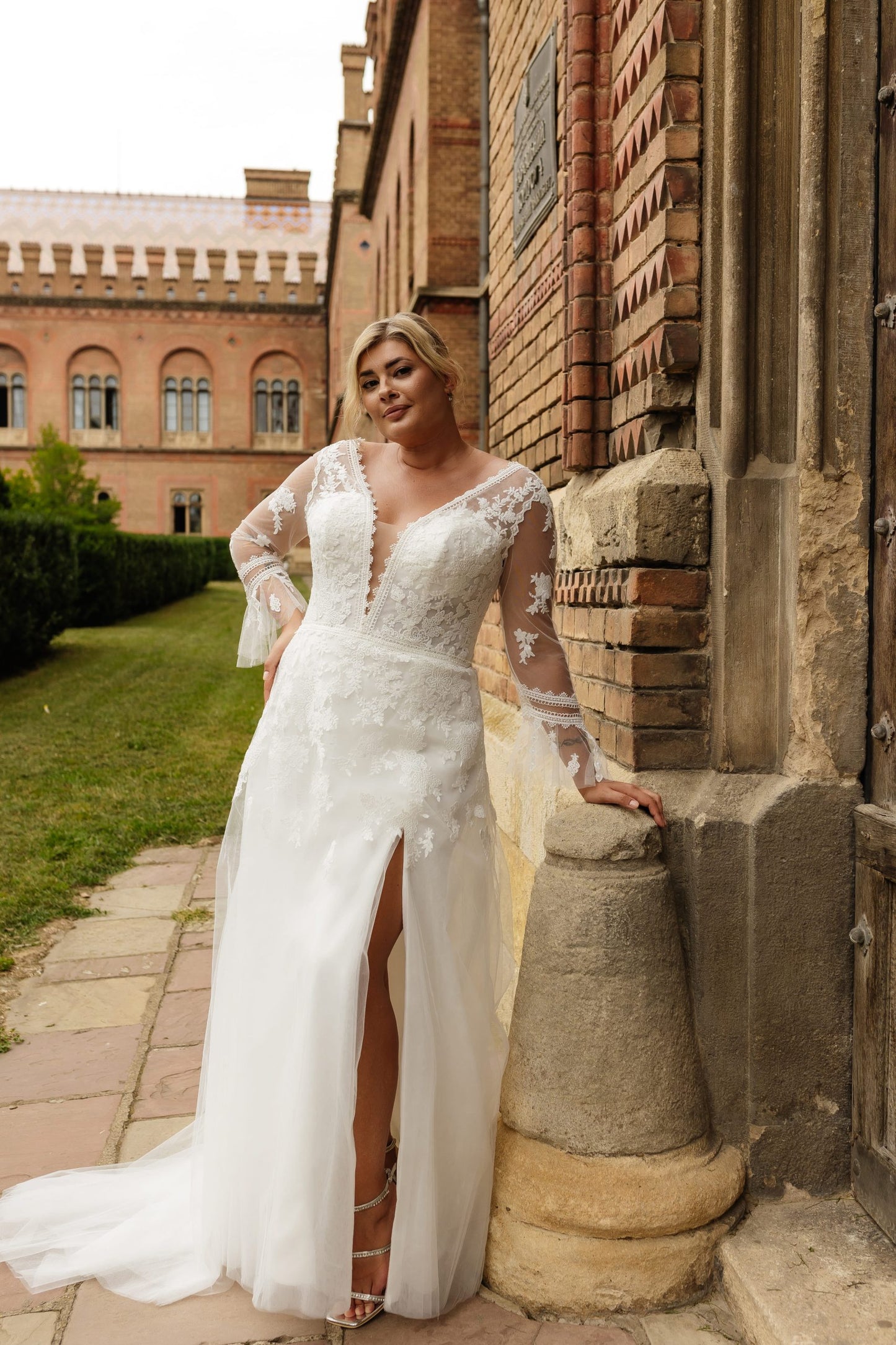 Boho-inspired plus-size wedding dress with deep V neckline, lace bodice, and thigh-high side slit