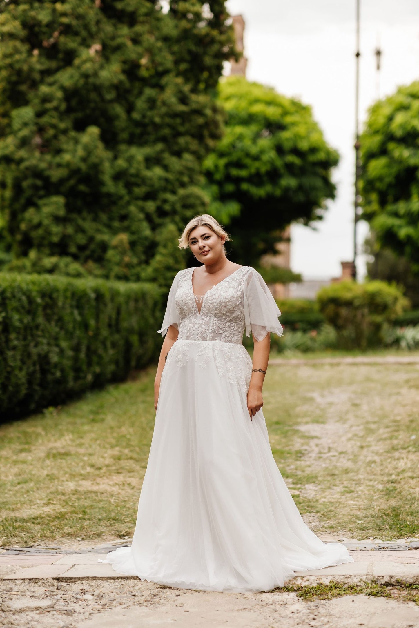 Boho plus-size A-line wedding dress with V-neckline and lace applique bodice