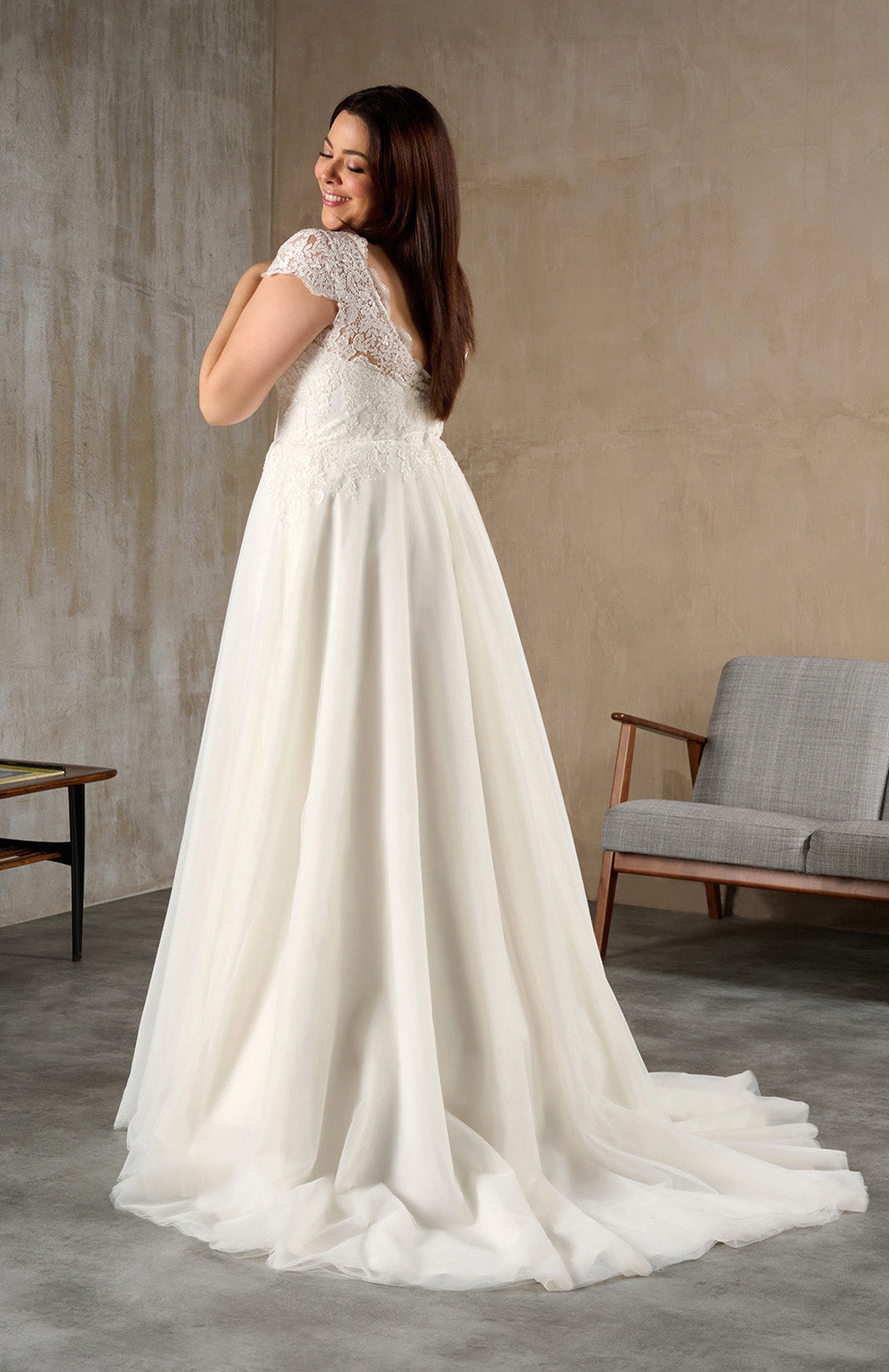 Back view of plus size wedding gown with sweep train and lace bodice