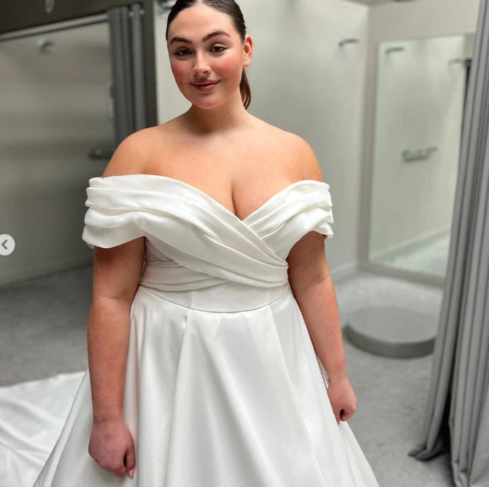 Classic plus size satin bridal dress with sweeping train and practical side pockets