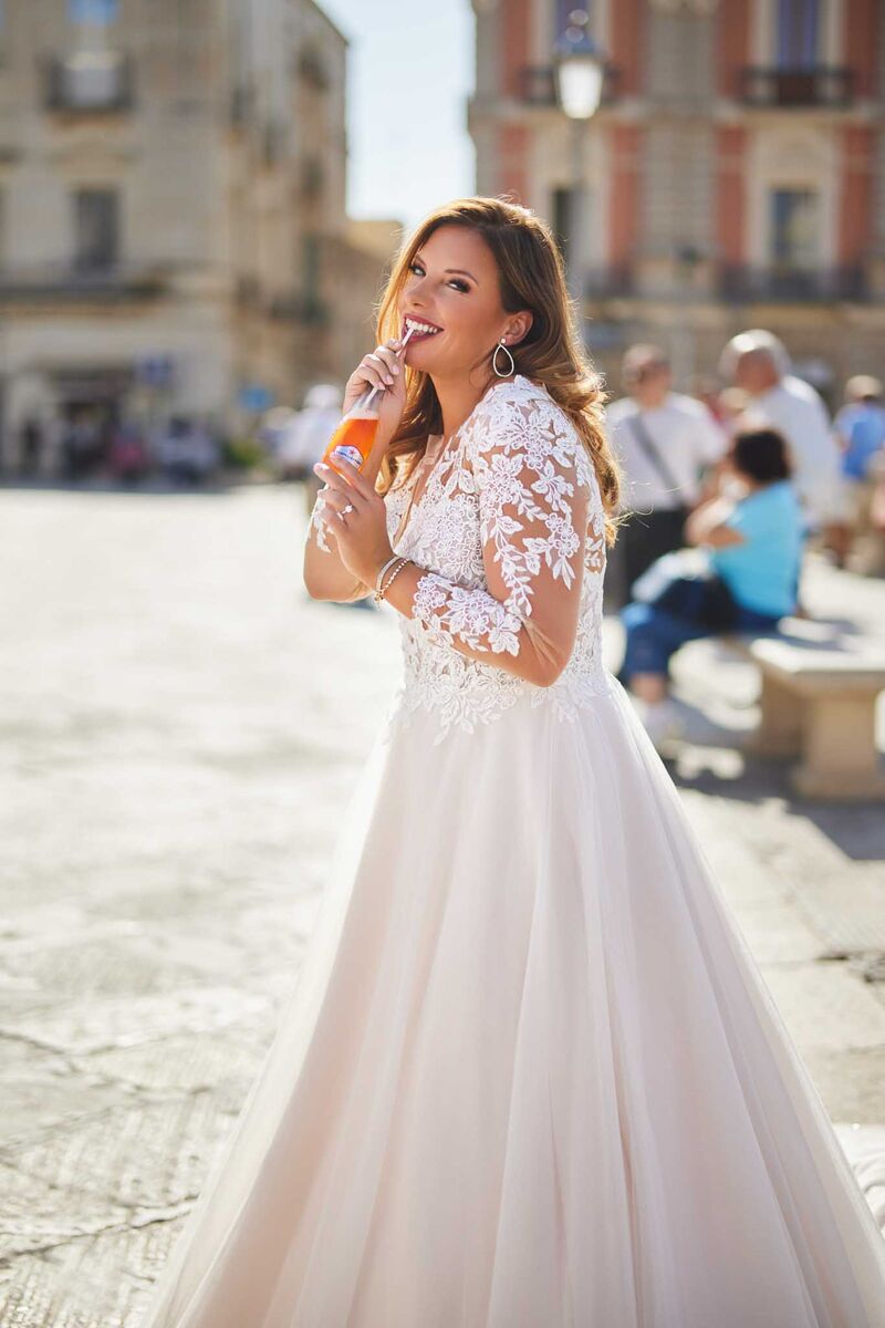 Plus-size bridal gown with sheer illusion lace back and pearl button detailing