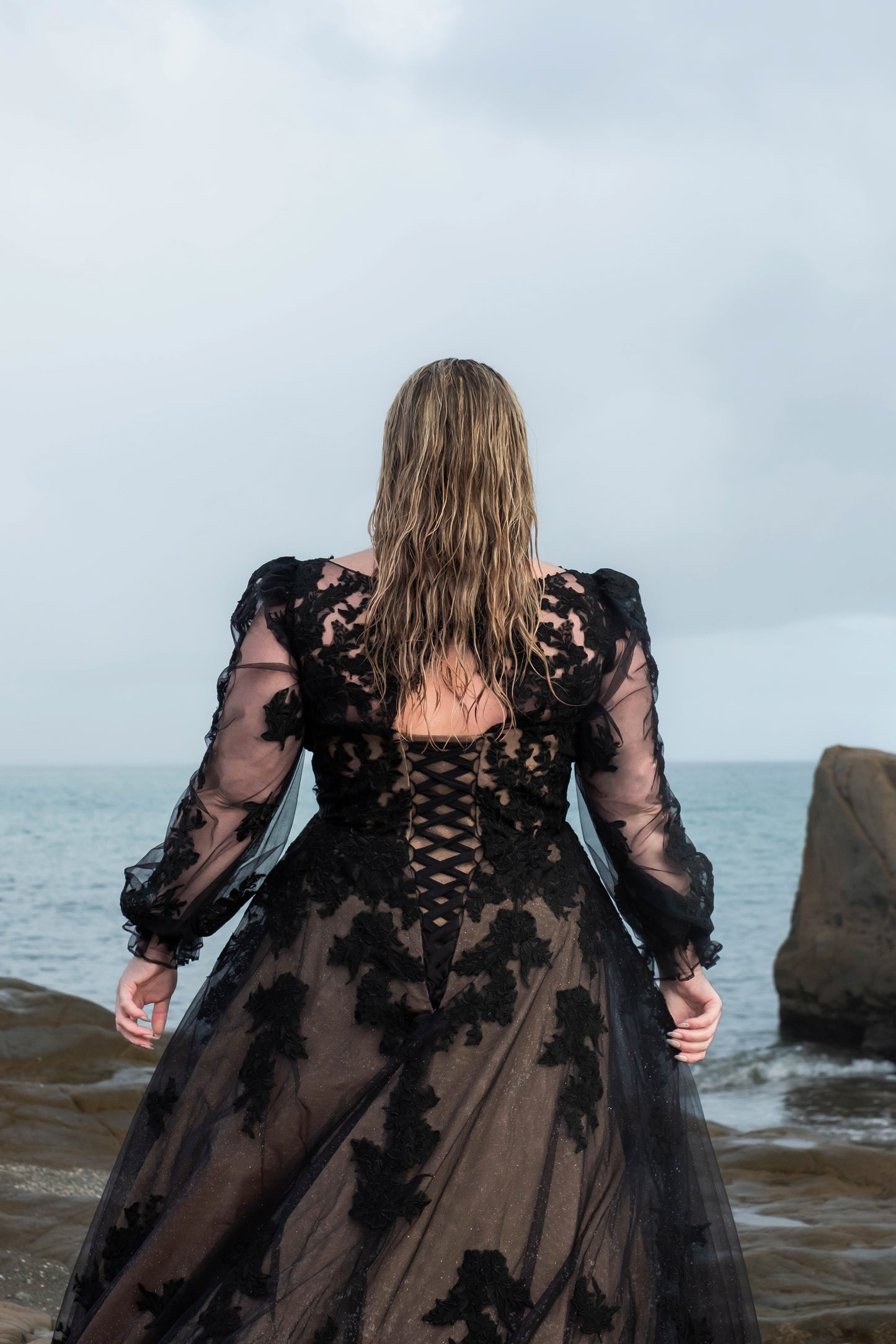 Plus size bridal dress with see-through sleeves and rich black floral lace details