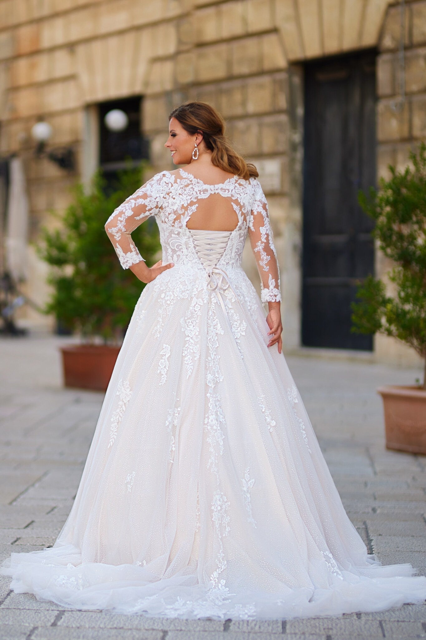 Luxury ball gown with tulle skirt, floral lace appliqués, and curve-enhancing structure for full-figured brides