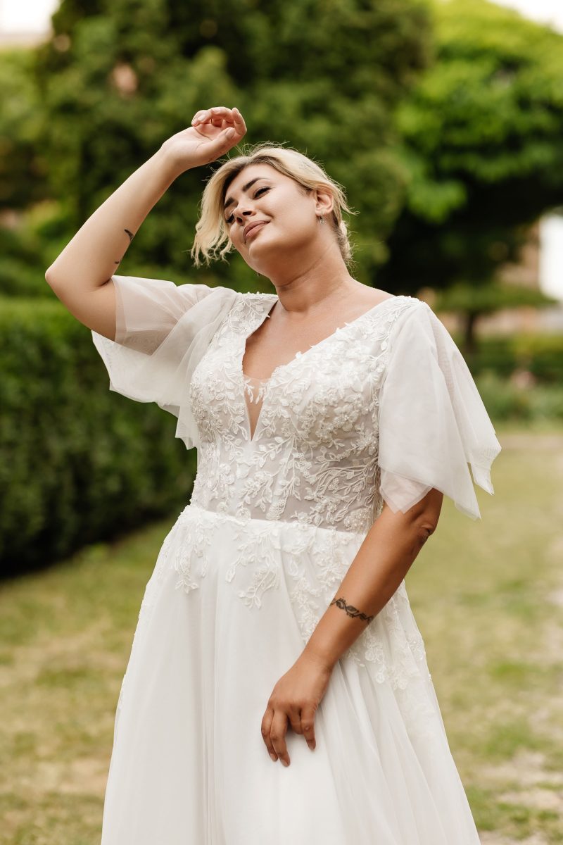 Romantic boho bridal gown for curvy brides with flutter sleeves and flowing chiffon skirt