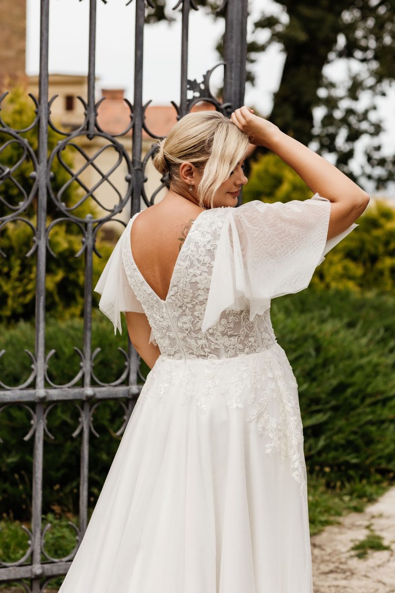 Vintage-inspired lace wedding dress with soft chiffon layers and deep V neckline for curvy bride

