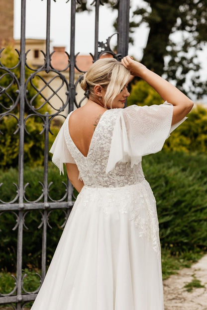 Vintage-inspired lace wedding dress with soft chiffon layers and deep V neckline for curvy bride

