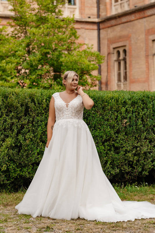 Lace A-line wedding dress designed for plus size brides with romantic cap sleeves

