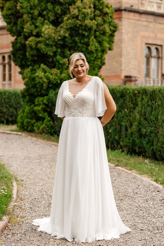 Plus-size wedding dress with illusion lace bodice, scoop neckline and flowy flutter sleeves