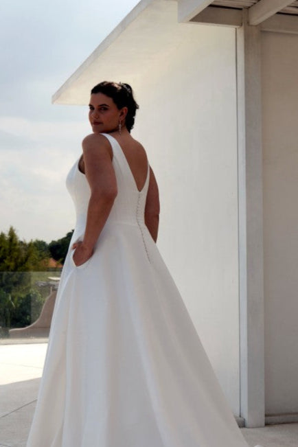 Modern minimalist plus-size wedding gown with smooth satin fabric and flattering structured bodice


