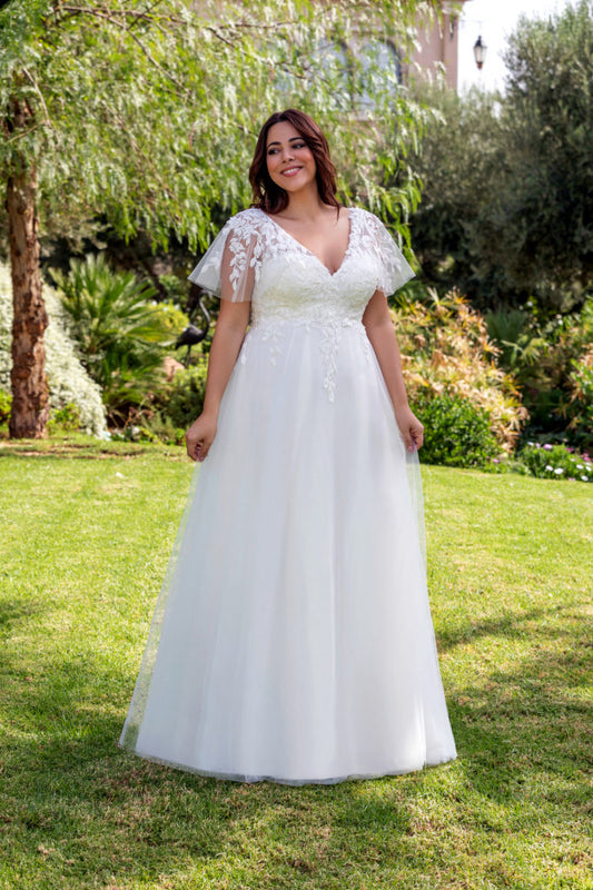 Plus size A-line wedding gown with deep V-neckline and romantic flowy silhouette
