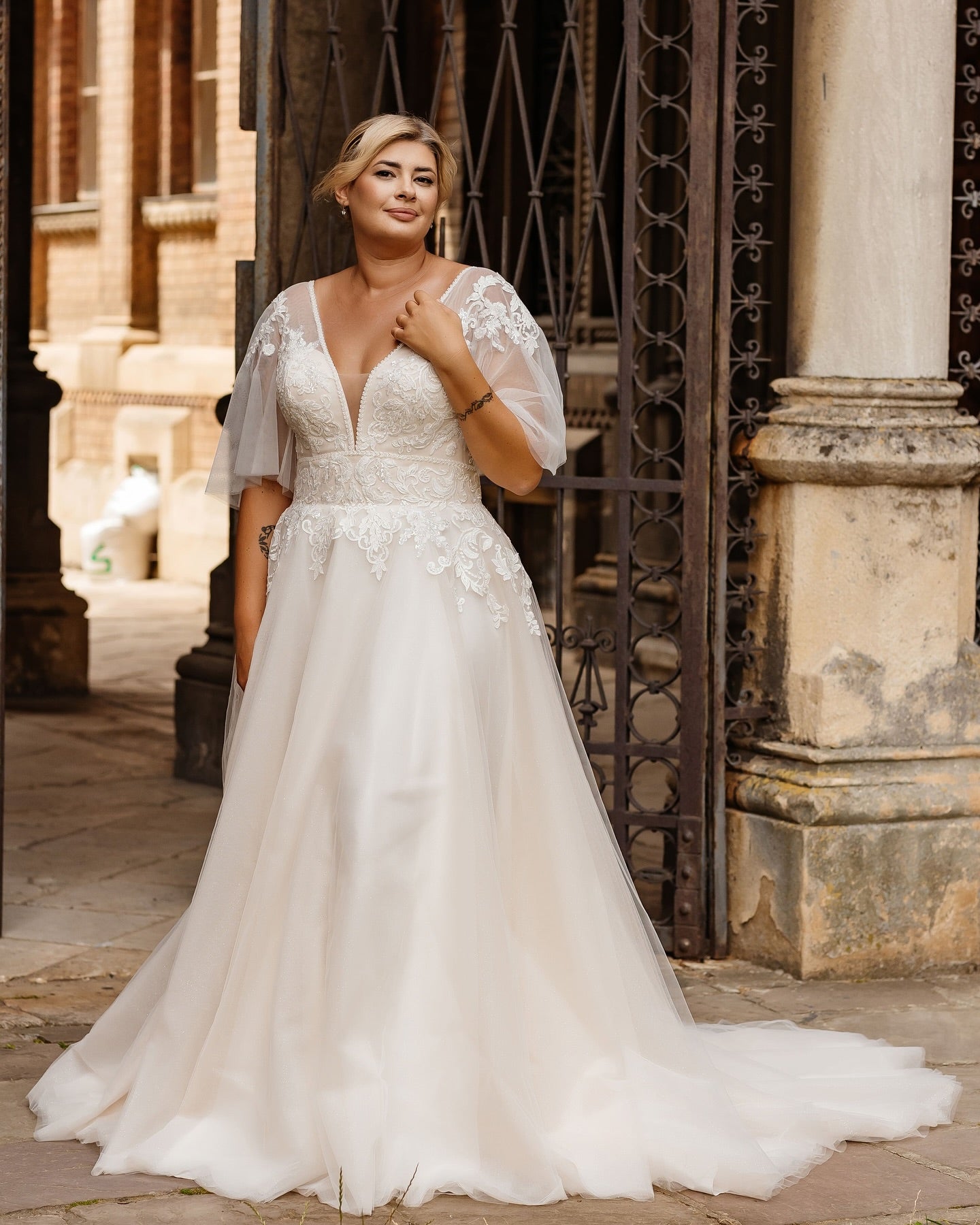 A romantic plus size boho lace wedding dress with soft tulle skirt and floral appliques