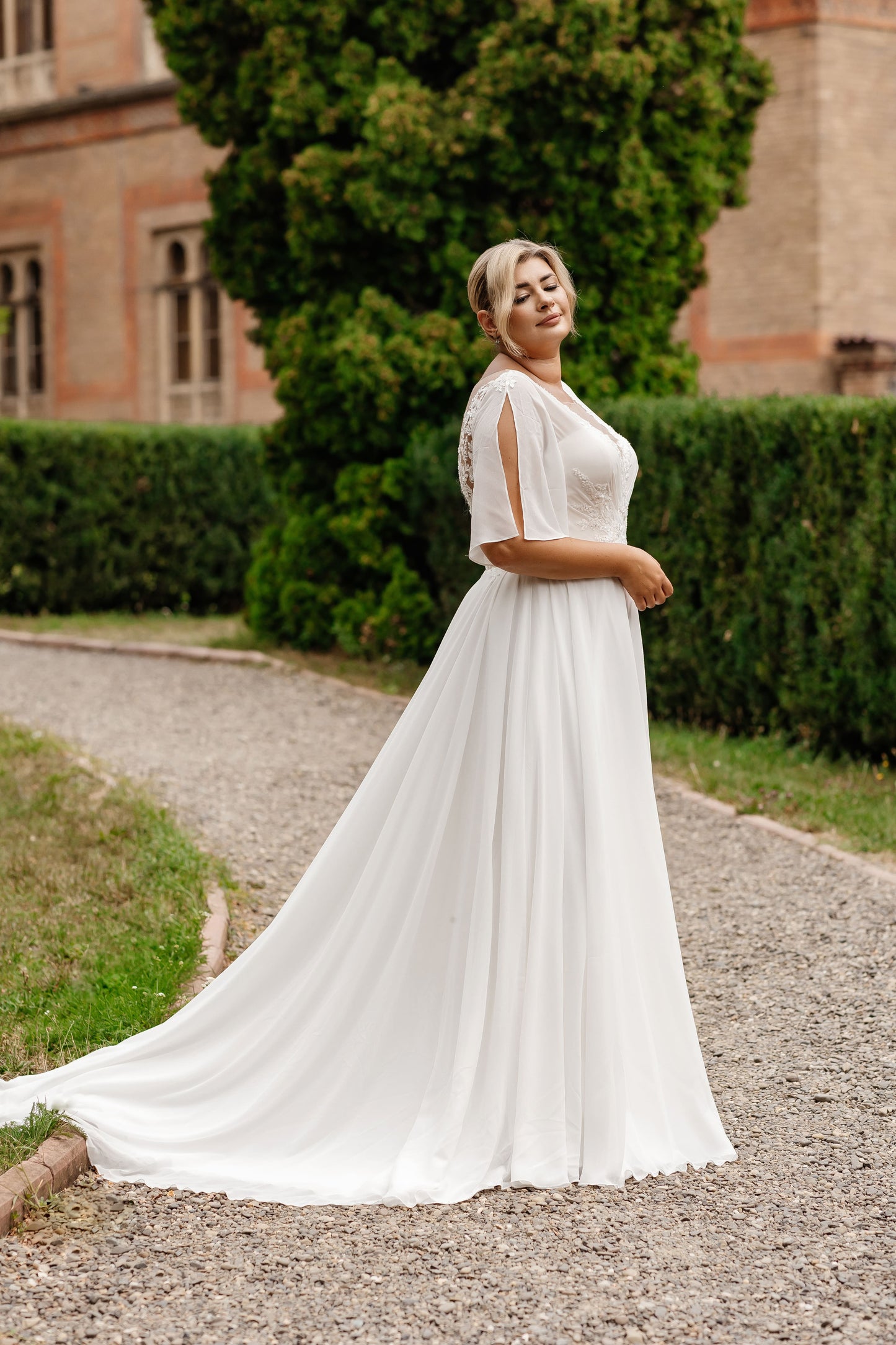 Full-figured chiffon wedding gown with flowing A-line skirt and sweep train for timeless elegance