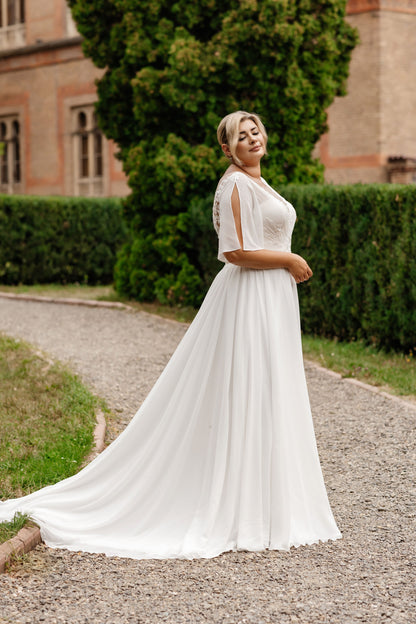 Full-figured chiffon wedding gown with flowing A-line skirt and sweep train for timeless elegance