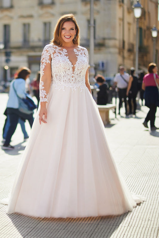 Romantic plus-size wedding dress with long illusion lace sleeves and flowing a-line tulle skirt