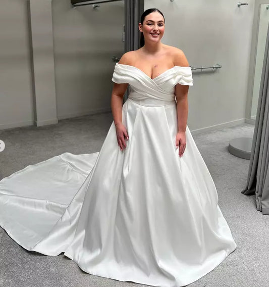 Elegant plus size off shoulder satin wedding gown with A-line silhouette and supportive bodice