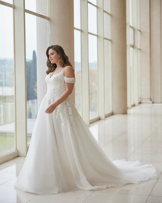 Plus size off shoulder wedding gown with flowing tulle and lace applique