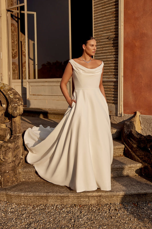 Plus size satin A-line wedding gown with scoop neckline and flowing ivory silhouette