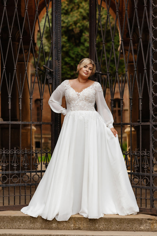 Front view of plus size chiffon wedding dress with puff sleeves and lace bodice