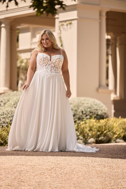 plus size wedding dress with chiffon skirt and lace bodice in natural sunlight

