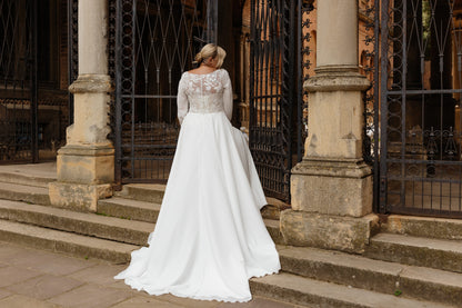 Plus size bridal gown with flowing chiffon and sweep train