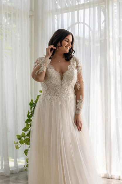 Curvy bride in V-neck lace wedding gown with tulle skirt and elegant long sleeves

